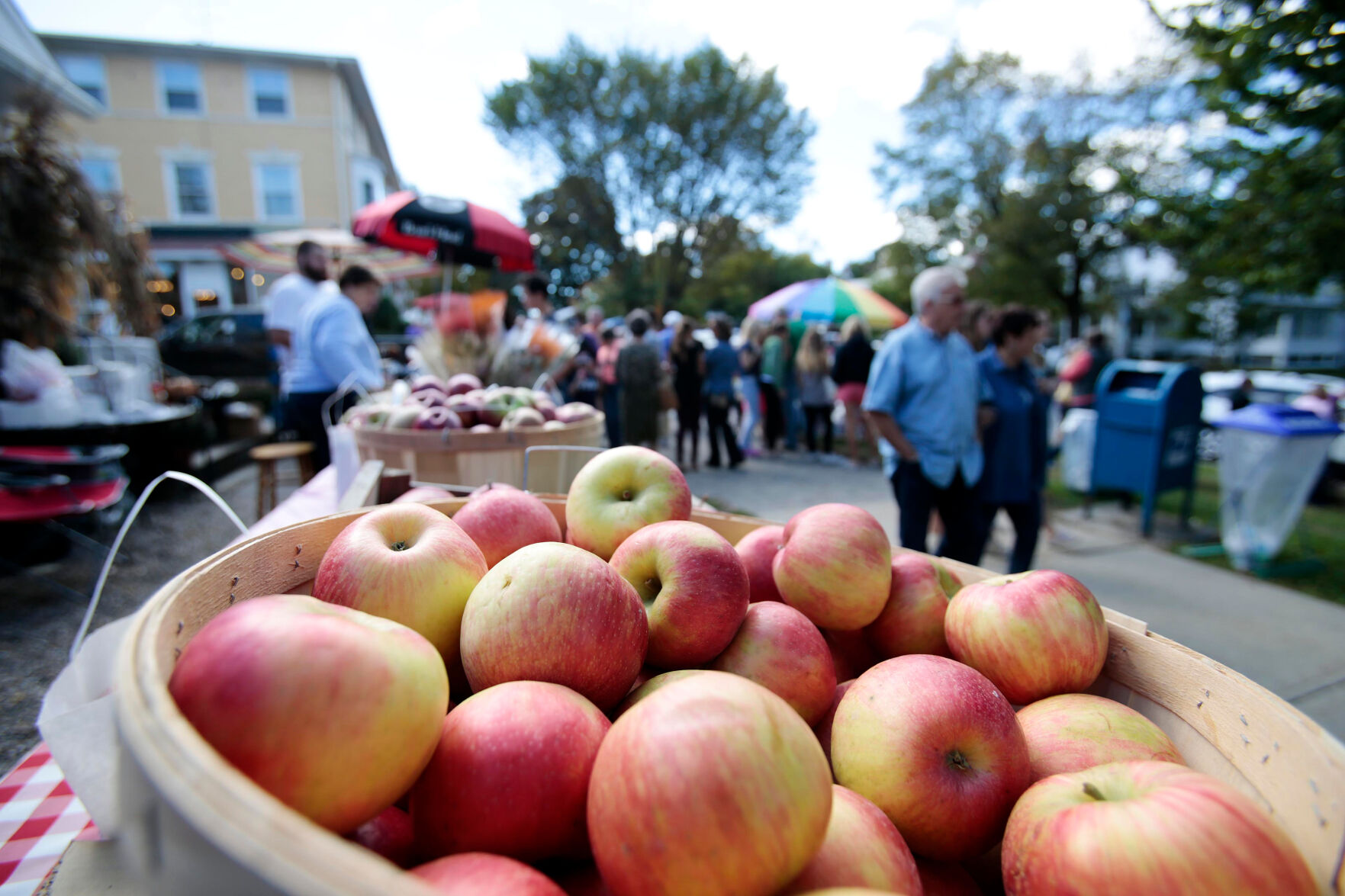 bushel of apples on a busy street full of vendors
